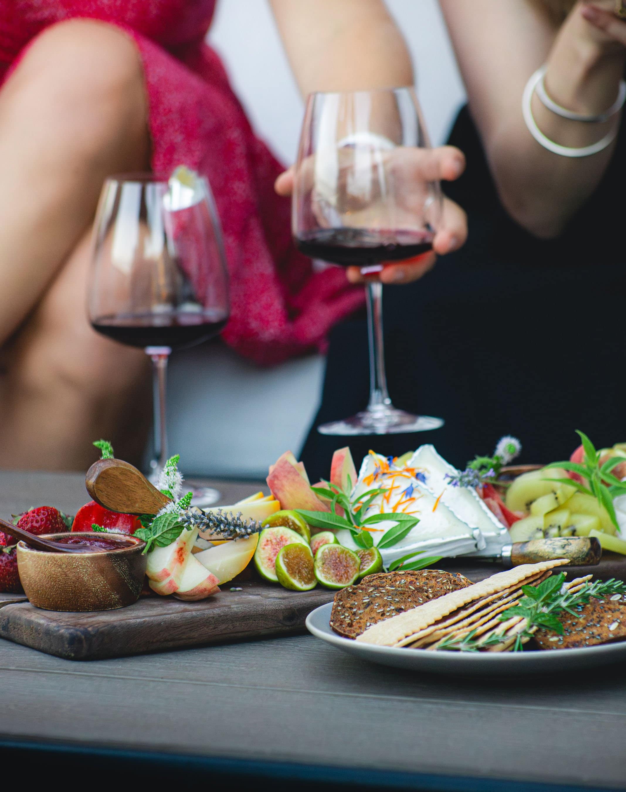 Wine Glasses with red wine, posed next to a charcuterie board