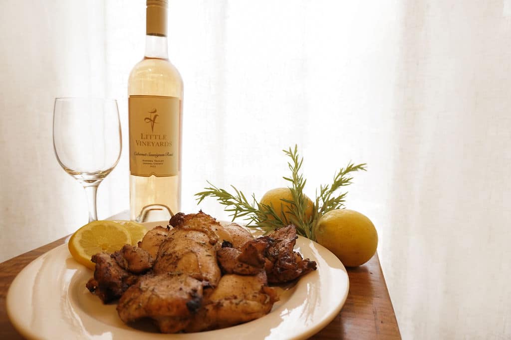 Table Setting featuring a bottle of 2023 Rose and the herb grilled chicken